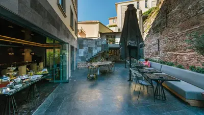 a patio with tables and a umbrella and a building at Hotel Saint Sophia in Istanbul