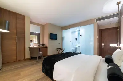 a bedroom with a large white bed and a desk at Hotel Saint Sophia in Istanbul