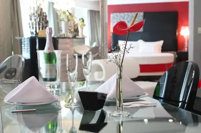 a glass table with a vase with a red flower on it at Surmeli Istanbul Hotel in Istanbul