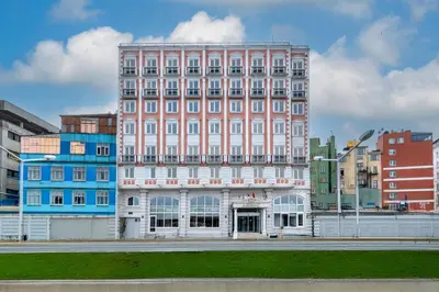 a large pink building in the middle of a city at Askoc Hotel & SPA in Istanbul