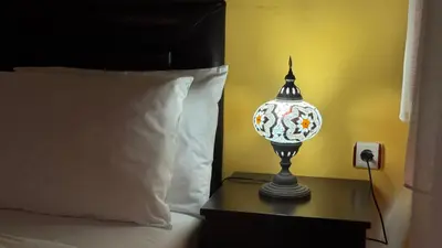 a small lamp on a table next to a bed at Cosmopolitan Park Hotel in Istanbul