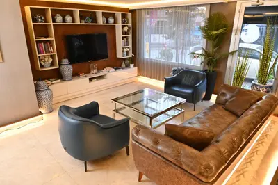 a living room with a leather couch and two chairs at Sogut Hotel Old City in Istanbul