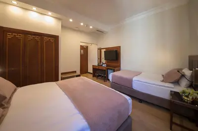 a hotel room with two beds and a desk at Vardar Palace Hotel - Special Category in Istanbul