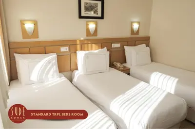 two beds in a hotel room with white sheets at Sude Konak in Istanbul