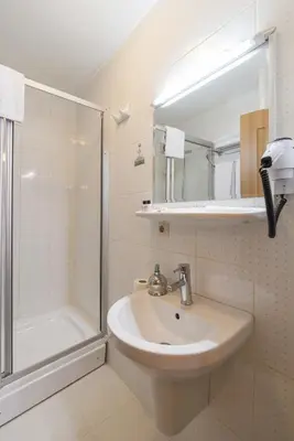 a white bathroom with a sink and a shower at Deniz Houses in Istanbul