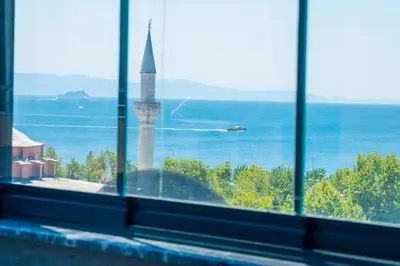 a window with a view of the ocean and a mosque at Miss Royal Hotel & SPA in Istanbul