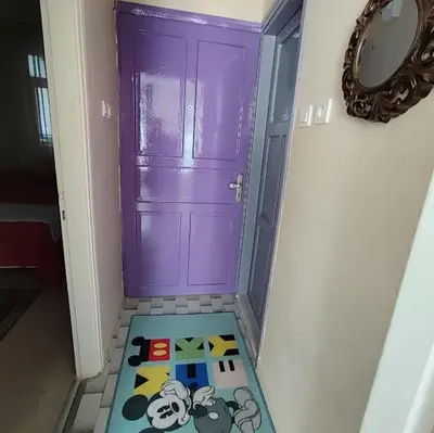 a purple door with a mickey mouse rug in front of it at Nur home1 in Istanbul