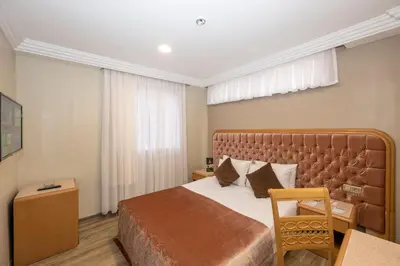 a hotel room with a large bed and a table at Grand Anka Hotel in Istanbul