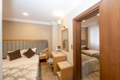 a hotel room with two beds and a desk at Grand Anka Hotel in Istanbul