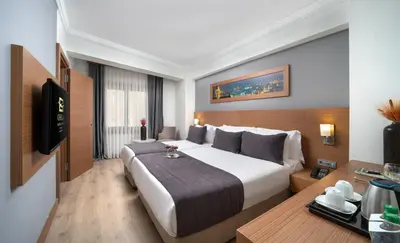 a hotel room with a large bed and a desk at Orka Royal Hotel & Spa in Istanbul