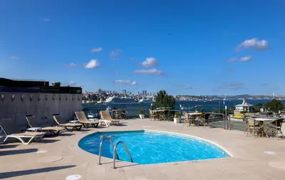 a pool on the roof of a building with chairs and tables at Orka Royal Hotel & Spa in Istanbul