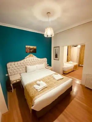 a bedroom with a large bed and a blue wall at Adora Hotel in Istanbul