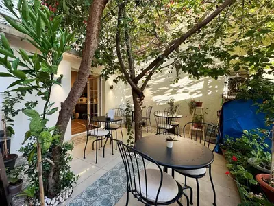 a patio with tables and chairs and trees at Sultan Pier Hotel in Istanbul
