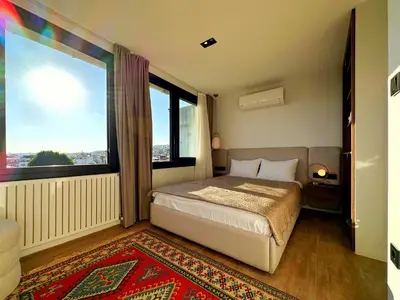 a bedroom with a bed and a large window at Sultan Pier Hotel in Istanbul
