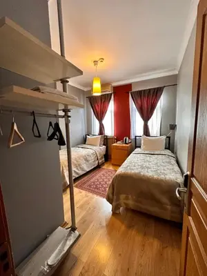 a bedroom with two beds and red walls at Ahmet Efendi Evi in Istanbul