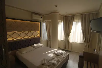 a hotel room with a bed and two windows at Grand Liza Hotel in Istanbul