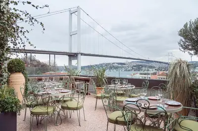 a patio with tables and chairs and a bridge at Crowne Plaza Istanbul - Ortakoy Bosphorus by IHG in Istanbul