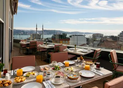 a table with food on a balcony with a view at Crowne Plaza Istanbul - Ortakoy Bosphorus by IHG in Istanbul