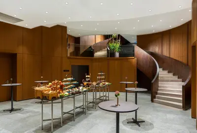 a lobby with a staircase and tables with desserts at Crowne Plaza Istanbul - Ortakoy Bosphorus by IHG in Istanbul