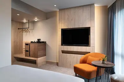 a room with a television and a chair and a table at Crowne Plaza Istanbul - Ortakoy Bosphorus by IHG in Istanbul