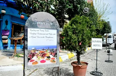 a sign for a restaurant with a tree in a street at The Sunrise Hotel in Istanbul