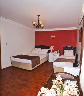 a bedroom with two beds and a red wall at The Sunrise Hotel in Istanbul