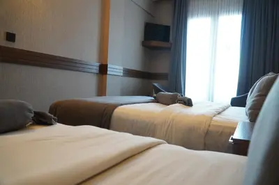 two beds in a hotel room with a window at Bern Hotel in Istanbul