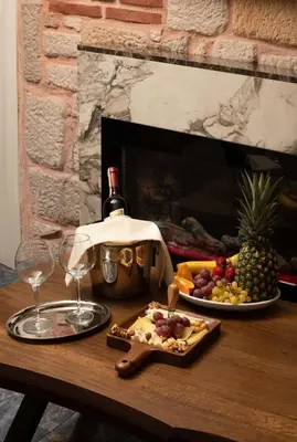 a table with a bottle of wine and a plate of fruit at REN PLUS SUITES in Istanbul