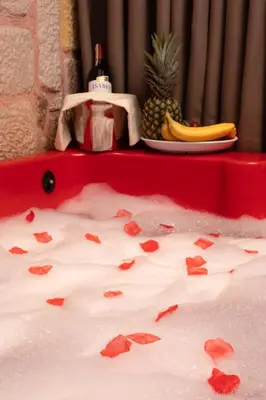 a red bath tub with a plate of fruit and a pineapple at REN PLUS SUITES in Istanbul