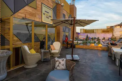 a patio with chairs and tables and an umbrella at Ramada By Wyndham Istanbul Pera Taksim in Istanbul
