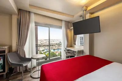 a hotel room with a red bed and a large window at Ramada By Wyndham Istanbul Pera Taksim in Istanbul