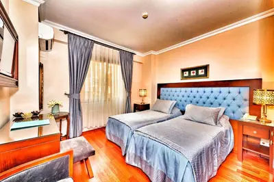 a bedroom with two beds and a window at Hotel Daphne in Istanbul