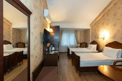 a hotel room with two beds and a mirror at Pera Rose Hotel & Spa - Special Category in Istanbul