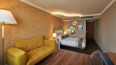 a hotel room with a couch and a bed at Richmond Istanbul in Istanbul