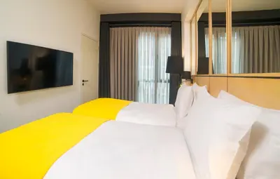 a bedroom with a white and yellow bed and a window at Trip Park Hotel in Istanbul