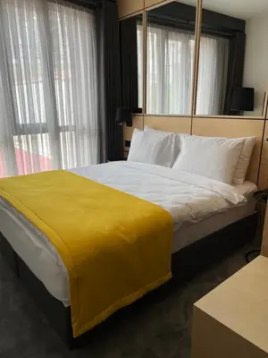 a bedroom with a large bed with a yellow blanket at Trip Park Hotel in Istanbul