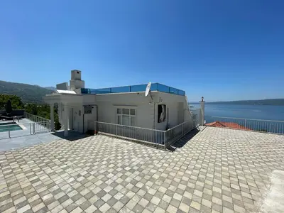 a house with a patio and a view of the water at WHİTE ROSE VİLLA Jakuzili ve Isıtma Havuzlu in Sapanca