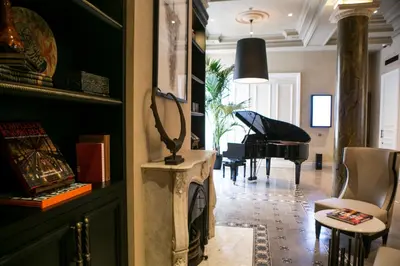 a living room with a piano and a room with a table at The Bank Hotel Istanbul, a Member of Design Hotels in Istanbul