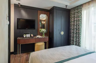 a bedroom with a bed and a vanity and a television at Tria Hotel Istanbul-Special Category in Istanbul