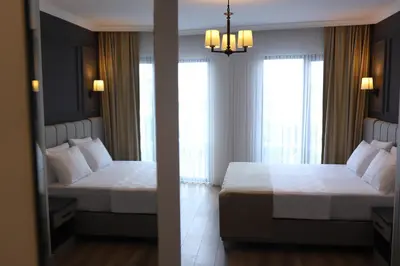 two beds in a hotel room with two windows at FONTANA VERDE in Istanbul