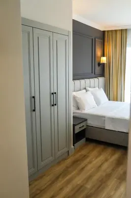 a bedroom with a white bed and a closet at FONTANA VERDE in Istanbul