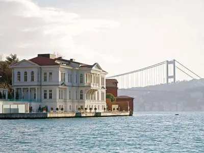 a large house on the water with a bridge in the background at A'jia Hotel in Istanbul