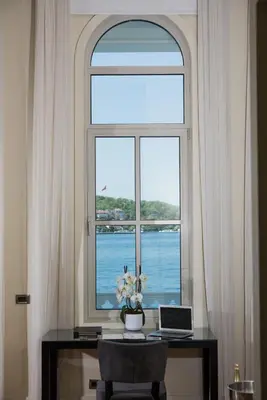 a window with a desk with a laptop and flowers at A'jia Hotel in Istanbul