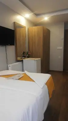 a bedroom with a large white bed and wooden cabinets at Mr Lion Kumkapı Otel in Istanbul