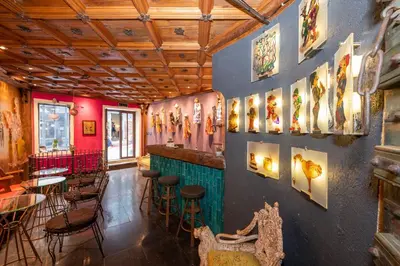 a restaurant with a bar with stools and paintings on the wall at Taksim Antique Hotel in Istanbul