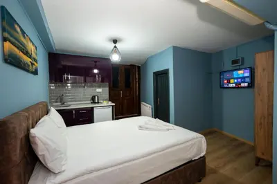 a bedroom with a white bed and a kitchen at Taksim Antique Hotel in Istanbul