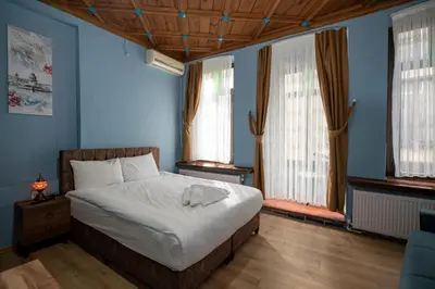 a bedroom with a bed with blue walls and windows at Taksim Antique Hotel in Istanbul