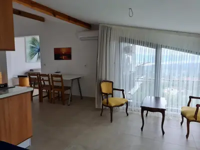 a kitchen and living room with a table and chairs at KD Apartments in Kartepe