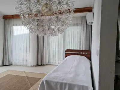 a room with a bed and a chandelier at KD Apartments in Kartepe