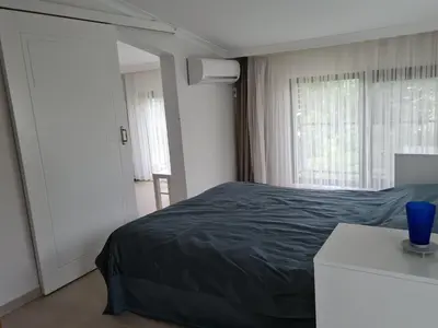 a bedroom with a bed and a blue vase on a table at KD Apartments in Kartepe